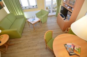 ein Wohnzimmer mit grünen Möbeln und einem Tisch in der Unterkunft Wohnpark Stadt Hamburg - Apt. 15 in Binz
