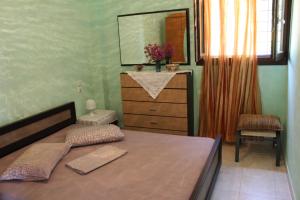 a bedroom with a bed with a dresser and a mirror at Apartments Spiros Pelion in Kalamaki