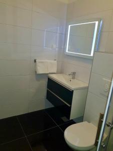 a bathroom with a sink and a toilet and a window at Bara Bay in Metajna