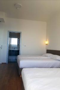 two beds in a hotel room with a window at Bara Bay in Metajna