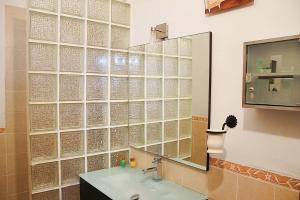 a bathroom with a glass wall with a sink and a mirror at Apartment Frasquita Boa in Júzcar