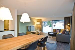 - un salon avec une grande table et des chaises en bois dans l'établissement Apartment Alperose - GriwaRent AG, à Interlaken