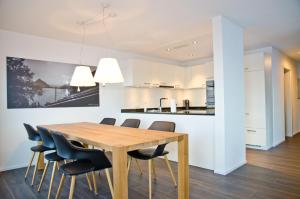 uma cozinha e sala de jantar com uma mesa de madeira e cadeiras em Apartment Alperose - GriwaRent AG em Interlaken
