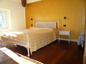 a bedroom with a bed and a yellow wall at Casa Beatrice in Oliveto Lario