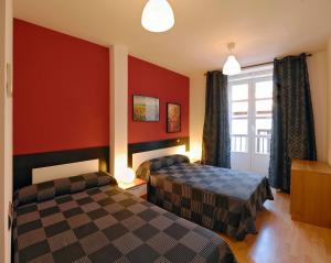 pokój hotelowy z dwoma łóżkami i oknem w obiekcie Apartamentos El Tiempo Madrid w Madrycie