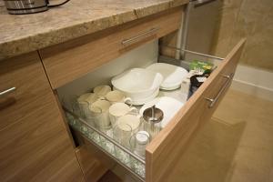 un armadio con piatti e ciotole in cucina di Petro delux apartments a Kaunas Altre 43 foto