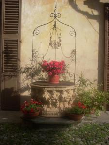 una fuente con flores delante de un edificio en Case Vacanze La CORTE, en Orta San Giulio