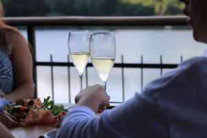 dos copas de vino blanco en una mesa con comida en Hotel Al Lago, en Lavarone