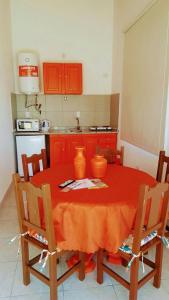una cucina con tavolo rosso e sedie e una cucina con armadi arancioni di Apart Raíces Federaenses a Federación