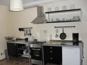 a kitchen with a stove and a counter top at Apartamentos na Casa São Bernardo in Alcobaça +41 photos