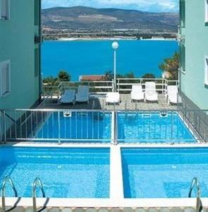 una grande piscina con vista sull'oceano di Apartments Villa Bayview a Trogir