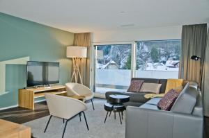 a living room with a couch and a tv at Apartment Krokus - GriwaRent AG in Interlaken