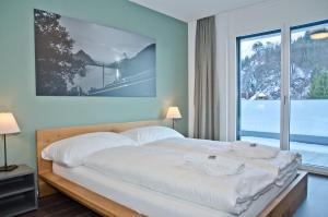 a bedroom with a bed and a large window at Apartment Krokus - GriwaRent AG in Interlaken