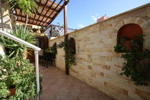 
a patio area with a stone wall and a brick wall at Sofia Pension in Rhodes Town
