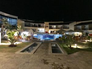 a hotel at night with a swimming pool at Pipa Solar Água Flat Master Luxo - 2 Quartos com Ar Condicionados Independente Apto 252 in Pipa