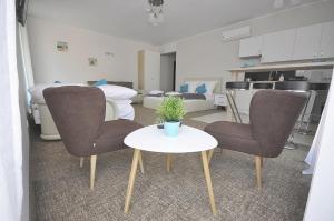 - un salon avec deux chaises et une table blanche dans l'établissement Apartamenty Patria, à Jastrzębia Góra