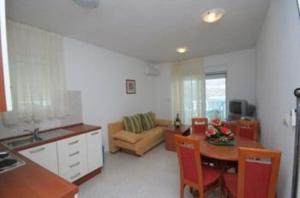 a kitchen and living room with a table and a couch at Apartments Villa Bayview in Trogir