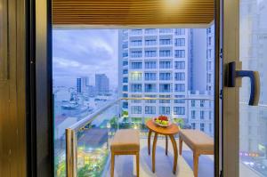a balcony with a table and chairs and a view of a city at Soho Boutique Hotel in Danang