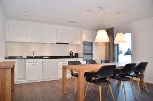 cocina y comedor con mesa de madera y sillas en Apartment Anemone - GriwaRent AG, en Interlaken