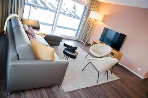 - un salon avec un canapé et une télévision dans l'établissement Apartment Anemone - GriwaRent AG, à Interlaken