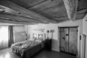 1 dormitorio con cama y techo de madera en Viandanti, Artisti e Sognatori en Comano