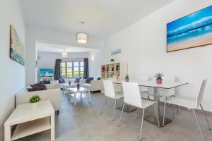 a living room with white tables and white chairs at Panorama in Port de Pollensa +16 photos