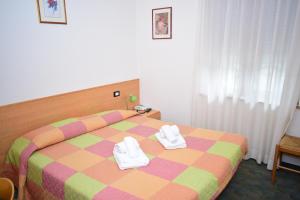 A bed or beds in a room at Albergo Alpino