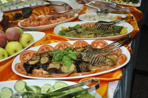 a table full of plates of food with tomatoes and vegetables at Kayalar Hotel in Antalya