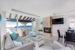 sala de estar con sofá y chimenea en Front Line Penthouse Puerto Banus With Sea Views, en Marbella