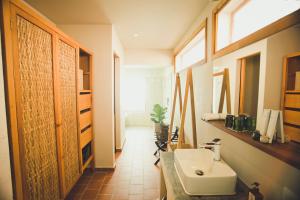 a bathroom with a white sink and a window at iRoHa Garden Hotel & Resort in Phnom Penh