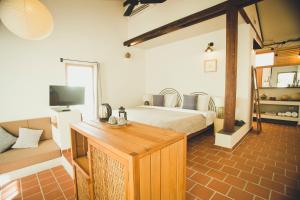 a bedroom with a bed and a couch and a television at iRoHa Garden Hotel & Resort in Phnom Penh