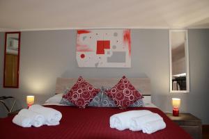 a bedroom with a red bed with towels on it at Livello Uno in Reggio di Calabria