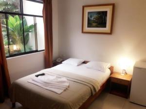 ein Schlafzimmer mit einem Bett mit Handtüchern darauf in der Unterkunft Amazon Green Hotel in Iquitos
