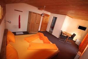 a bedroom with an orange bed and a desk at Haus Vallaster in Gaschurn