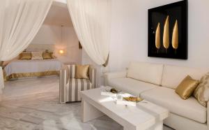 a living room with a couch and a bed at Gold Suites - Small Luxury Hotels of the World in Imerovigli