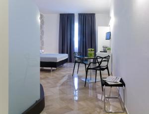 a room with a bed and a table and chairs at Viasparano B&B in Bari