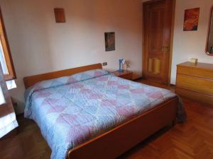 レッツェノにあるL'Agrifoglioのベッドルーム1室(青とピンクの掛け布団付きのベッド1台付)