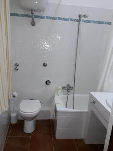 a white bathroom with a toilet and a sink at Le Tre Caravelle in Trabia