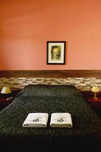 a bedroom with a bed with two towels on it at Hotel A Mi Gente in Castillos