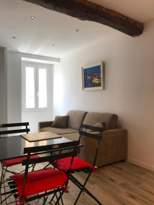 ein Wohnzimmer mit einem Sofa, einem Tisch und Stühlen in der Unterkunft Appartement de charme centre ville historique Ajaccio in Ajaccio