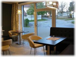 a restaurant with two tables and chairs and a window at Haus VITALIS - Guesthouse Burgenland in Sigless