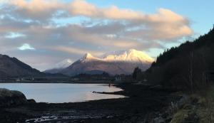 a lake with snow capped mountains in the background at Seaview Pod and hot tub in Ballachulish
