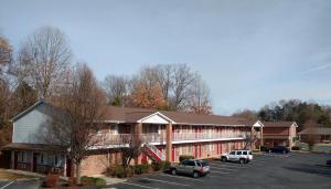 a large building with cars parked in a parking lot at Affordable Suites Charlottesville in Charlottesville