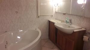 La salle de bains est pourvue d'un lavabo et d'une baignoire. dans l'établissement Clou Accomodation, à Aoste