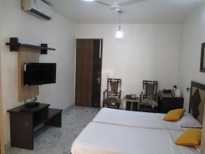 a bedroom with a bed and a flat screen tv at East End Retreat in New Delhi