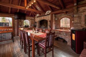 a dining room with a table and a fireplace at Vila Sara in Novo Zvecevo