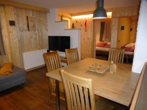 cocina y comedor con mesa de madera y sillas en Chalet Auszeit, en Arzl im Pitztal