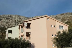 a building with a mountain in the background at Apartments Tea in Podaca