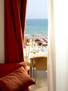 a table with a view of the beach through a window at Casa Del Mar in Roseto degli Abruzzi