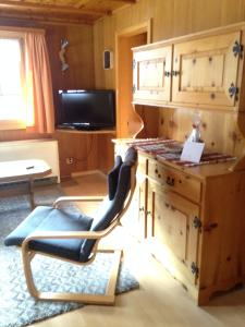 a chair in a room with a kitchen with a counter at Chalet Gärlich in Bürchen